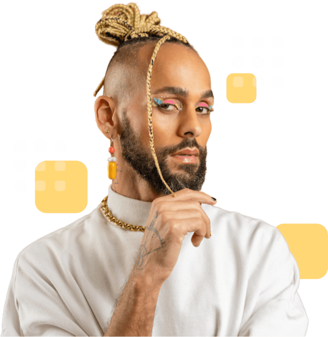Confident individual with braided topknot, beard, colorful eye makeup, and wearing a white top.