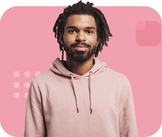 Individual with medium-length dreadlocks, wearing a pink hoodie, and standing confidently.