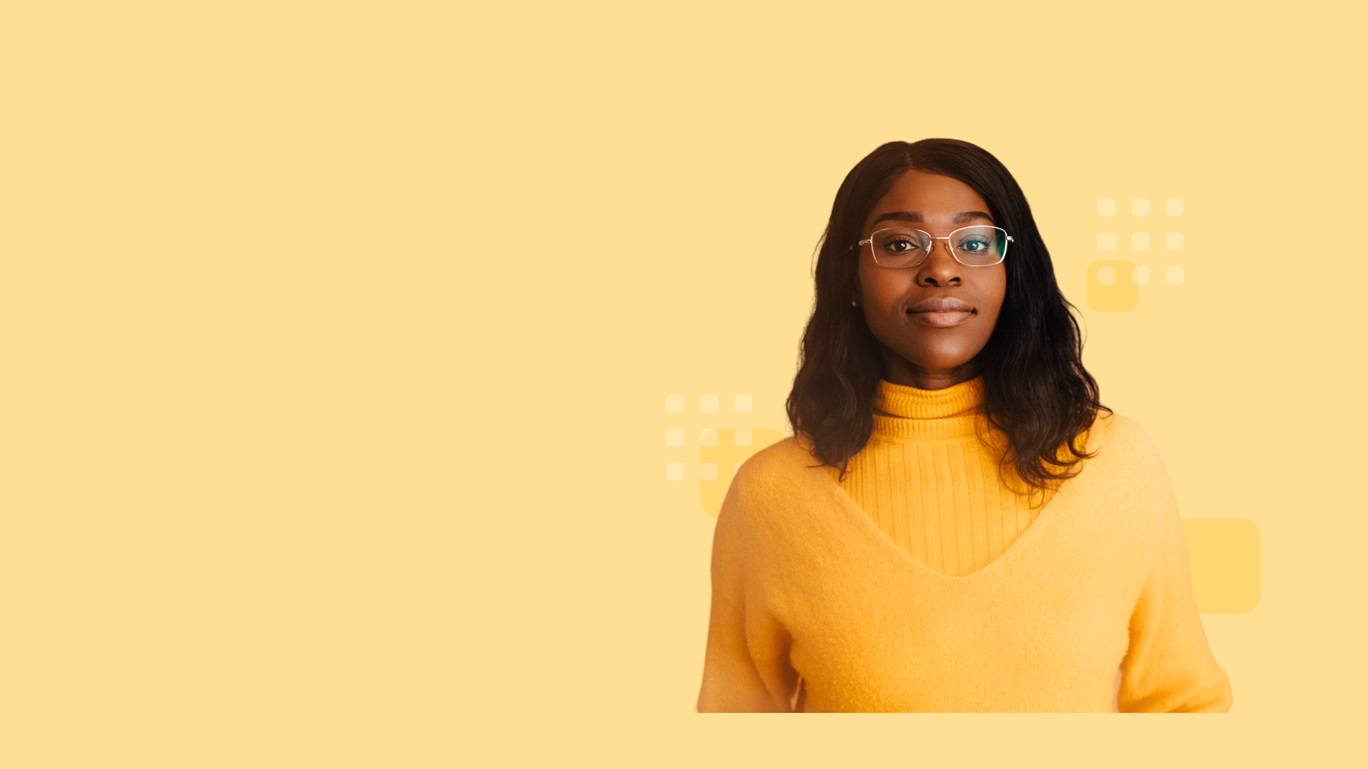 Confident person with shoulder-length hair and glasses, wearing a yellow sweater.