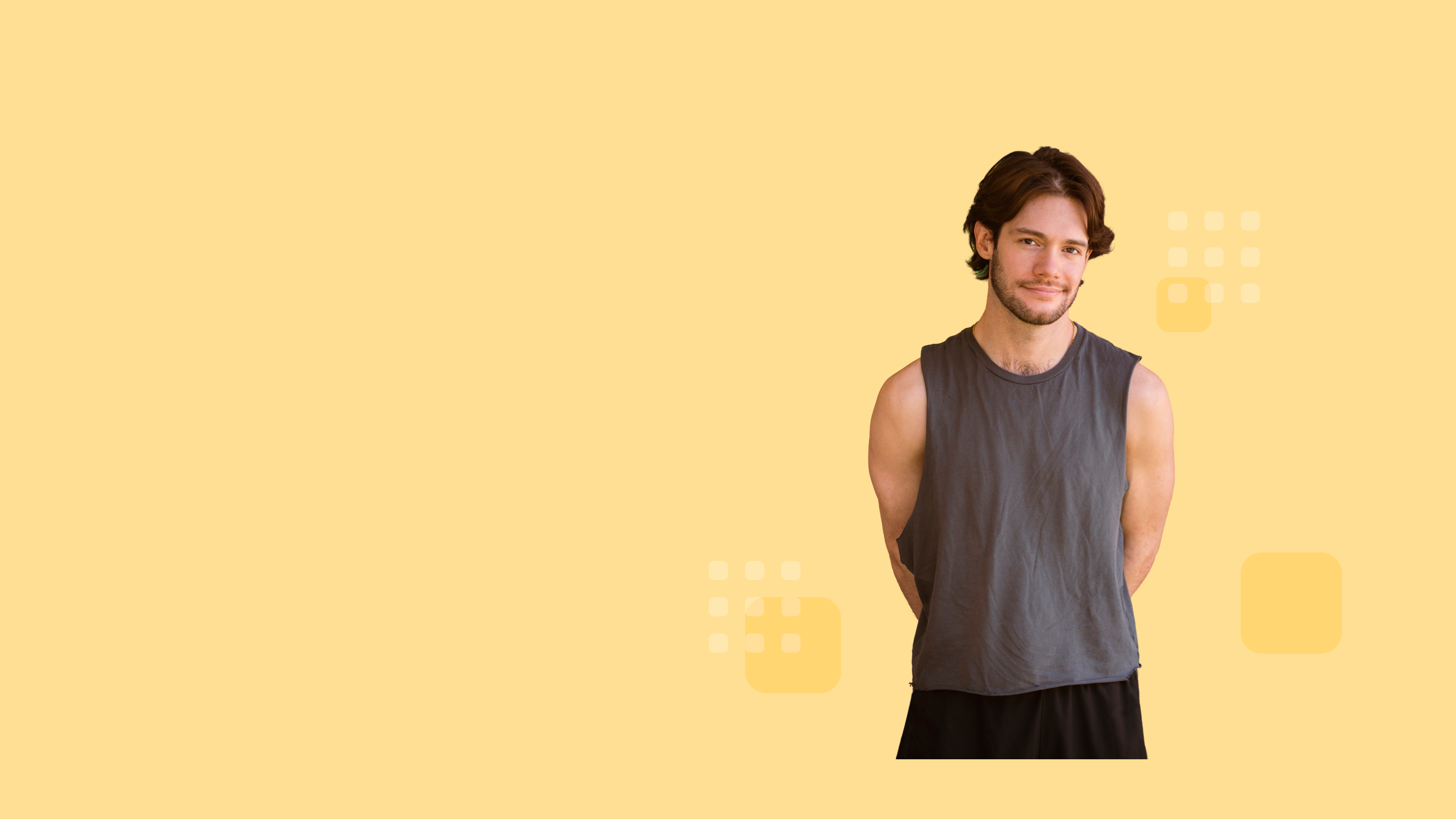 Smiling individual with medium-length hair, and wearing a sleeveless dark gray shirt, hands behind back.