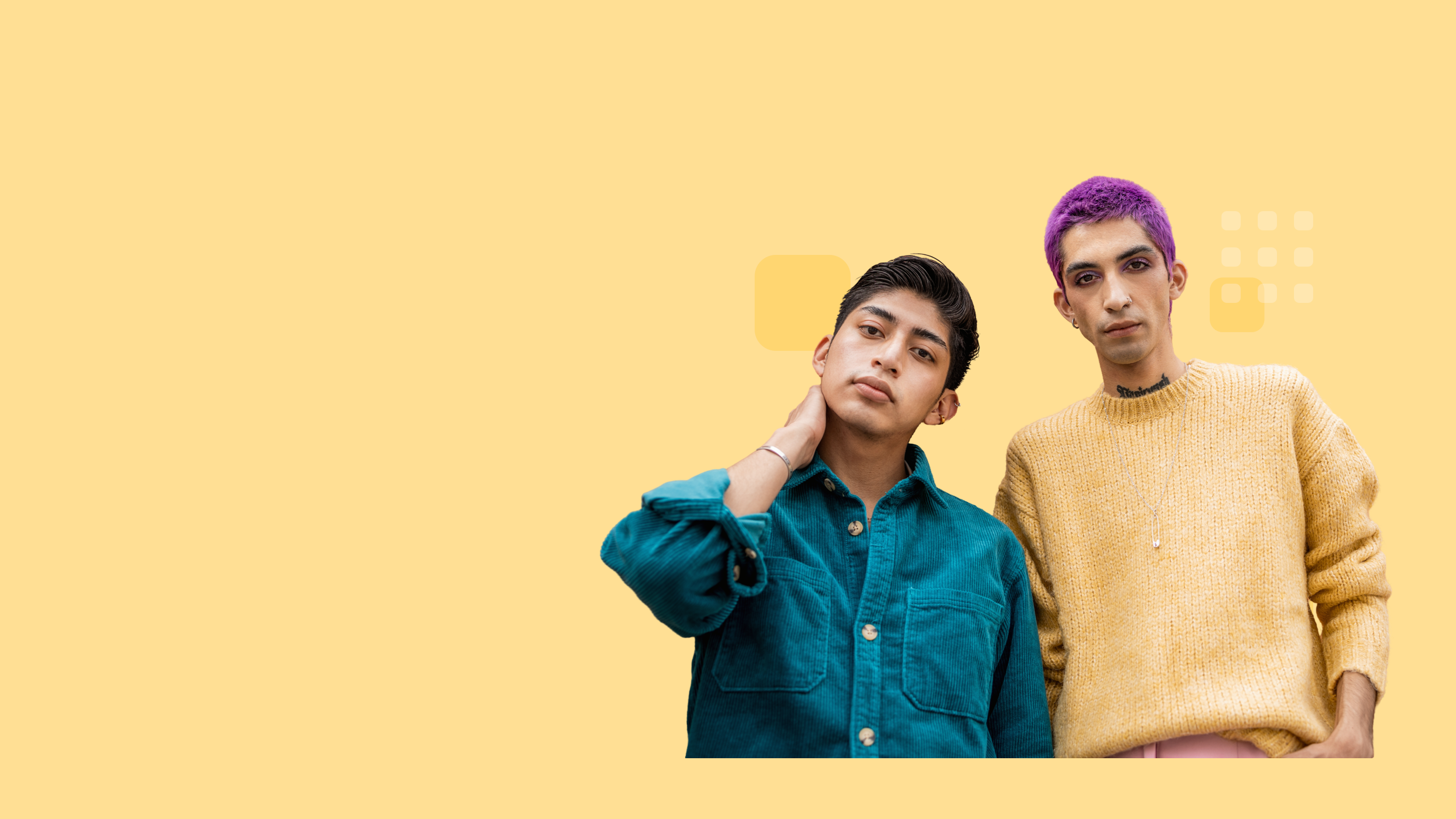 Two people standing confidently; one wearing a teal button-up shirt with hand on neck, the other with short purple hair, visible tattoos, and a yellow sweater.